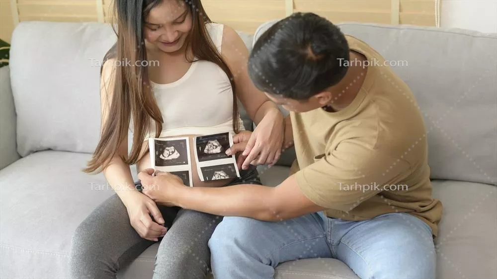عکس زن جوان باردار و همسرش در حال نگه داری سونوگرافی نوزاد - مفهوم خانواده و مادری