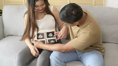 عکس زن جوان باردار و همسرش در حال نگه داری سونوگرافی نوزاد - مفهوم خانواده و مادری