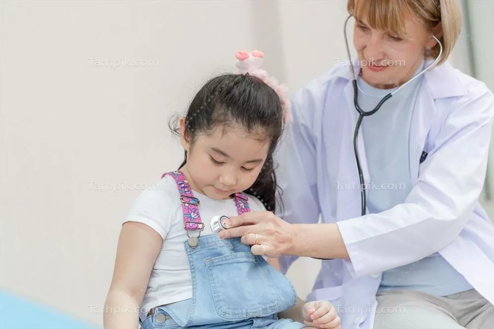 عکس پزشک زن در حال معاینه یک دختر بچه زیبا با استفاده از گوشی پزشکی
