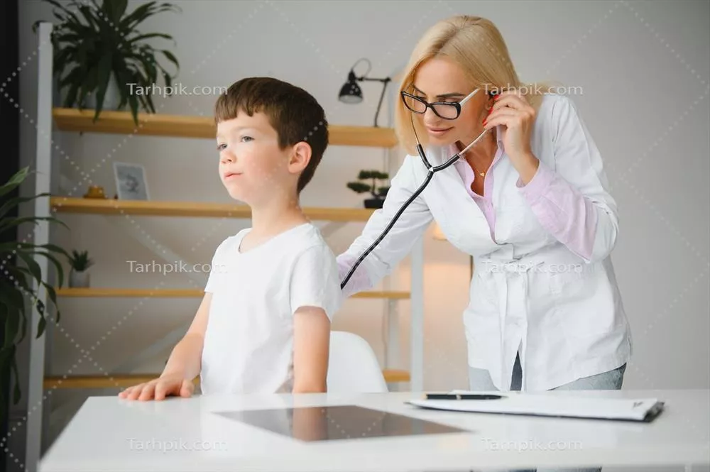 عکس پزشک اطفال در حال معاینه یک پسر بچه دوست داشتنی با گوشی پزشکی