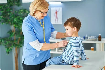 عکس پزشک اطفال در حال معاینه کودکان در کلینیک به صورت حرفه ای
