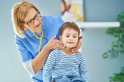 عکس پزشک اطفال در حال معاینه کودکان کوچک در کلینیک پزشکی