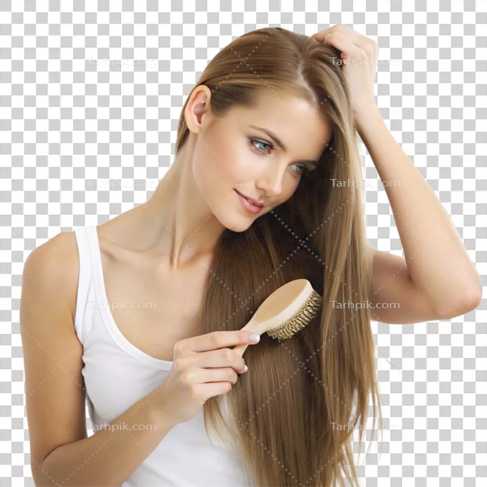 عکس دوربری زنی در حال شانه زدن به موی بلندش در یک اتاق روشن و زیبا