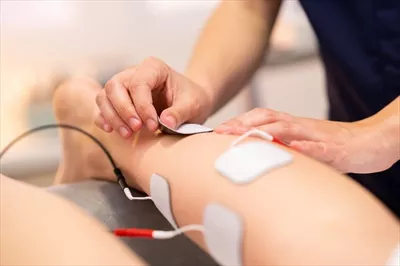 عکس تحریک الکتریکی در فیزیوتراپی برای بهبود وضعیت یک زن جوان