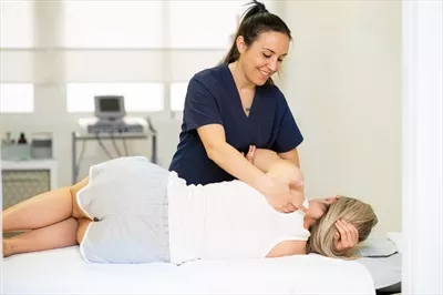 عکس فیزیوتراپیست در حال بررسی وضعیت بیمار خود در مرکز فیزیوتراپی