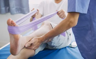 عکس پزشک یا فیزیوتراپیست در حال معاینه و درمان آسیب دیدگی بازوی یک ورزشکار