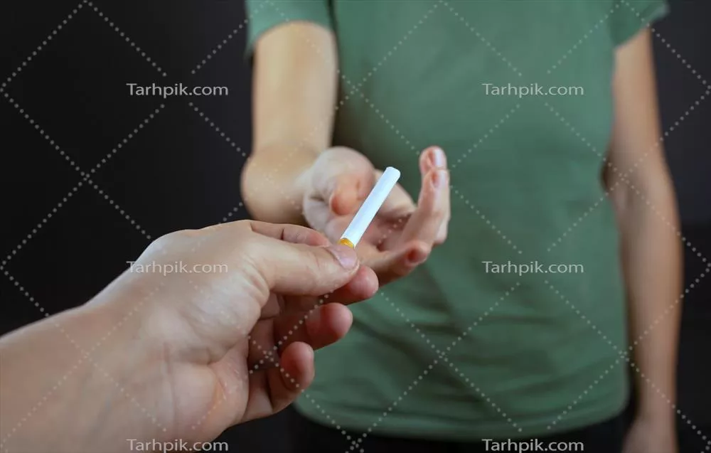 عکس لحظه ای جذاب: مردی که سیگاری به دختری در پس زمینه تاریک می دهد