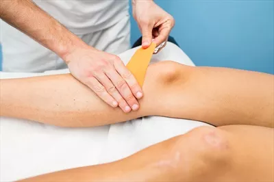 عکس نحوه استفاده از کینزیوتیپینگ برای درمان زانو توسط فیزیوتراپیست