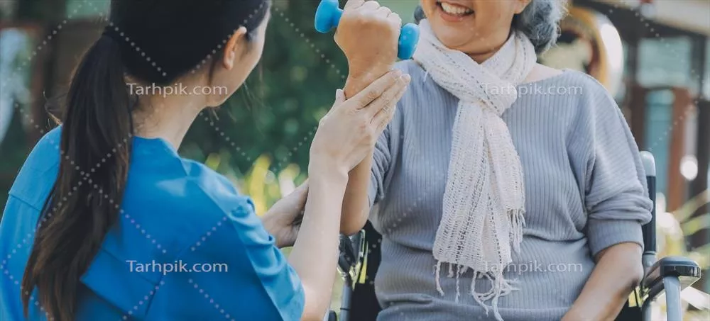 عکس پرستار جوان یا فیزیوتراپیست در حال کمک به یک زن سالخورده خوشحال برای انجام تمرینات ورزشی در خانه