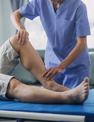 عکس پزشک یا فیزیوتراپیست در حال معاینه و درمان آسیب دیدگی بازوی یک ورزشکار