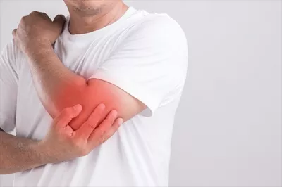 عکس مردی که در استودیو به آرنج خود فشار می آورد و احساس درد می کند