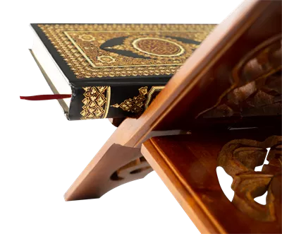 عکس دوربری قرآن کریم بر روی میز چوبی: نمادی از آرامش و معنویت