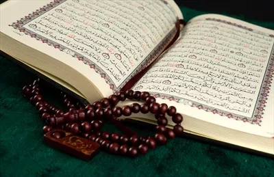 عکس کتاب قرآن باز و تسبیح به عنوان پس زمینه مذهبی زیبا و معنوی