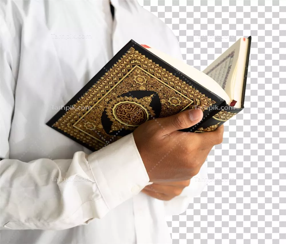 عکس دوربری مردی در حال خواندن قرآن با دقت و تمرکز بالا