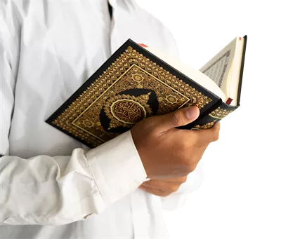 عکس دوربری مردی در حال خواندن قرآن با دقت و تمرکز بالا