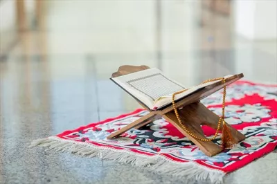 عکس مفهوم اسلامی قرآن کریم با خط عربی و تسبیح: درک عمیق از قرآن