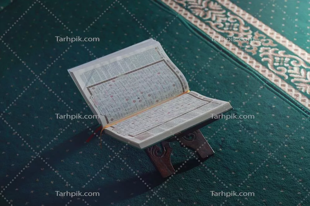 عکس تصویری نزدیک از قرآن کریم بر روی سجاده سبز در فضای اسلامی