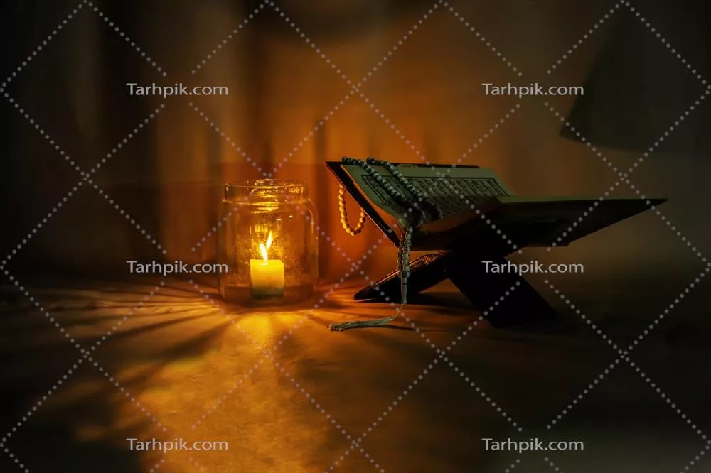 عکس قرآن کریم بر روی پایه چوبی قرار گرفته و شمع ها روشن هستند