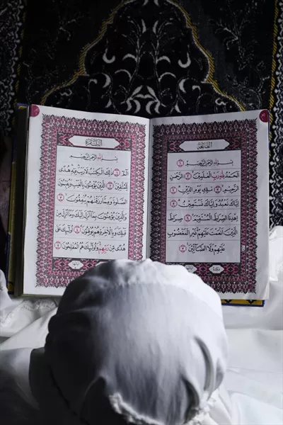 عکس دختر بچه ای که در حال خواندن قرآن است و مفهوم اسلامی را به تصویر می کشد