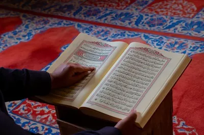 عکس مرد مسلمان در حال خواندن قرآن کریم در ماه رمضان