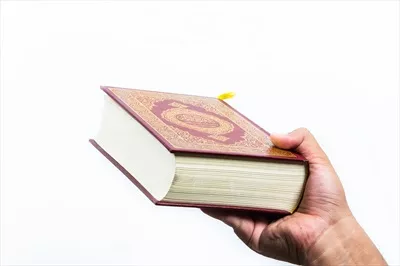 عکس قرآن در دست: کتاب مقدس مسلمانان و نماد ایمان اسلامی