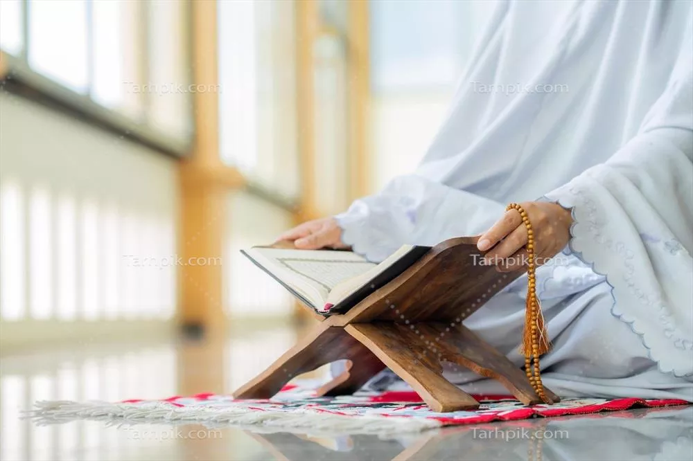 عکس مفهوم اسلامی: قرآن کریم با خط عربی و تسبیح در کنار آن