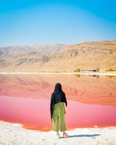 عکس زنی قفقازی در حال تماشای دریاچه نمک صورتی ماهارلو در شیراز