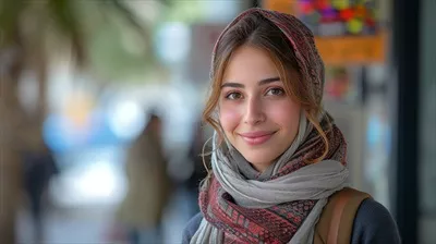 عکس دانشجوی جوان خاورمیانه ای با گوشی هوشمند و کتاب های درسی در حال قدم زدن در شهر