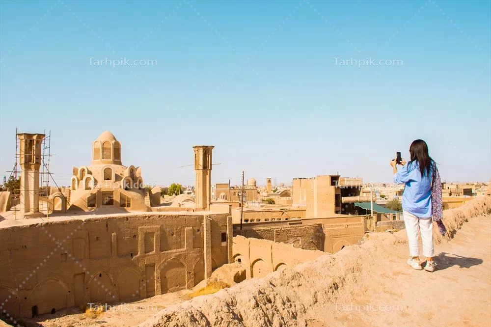 عکس منظره زیبا از بام کاشان با بادگیرها و گردشگران در روزهای گرم تابستان