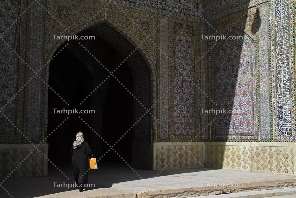 عکس زنی که به سایه ورودی مسجدی در کاشان ایران وارد می شود