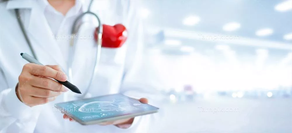 عکس تصویری از پزشک قلب با گوشی پزشکی و تبلت در حال تحلیل وضعیت بیمار