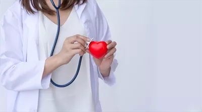 عکس پزشک با گوشی پزشکی در حال معاینه قلب قرمز و بررسی سلامت