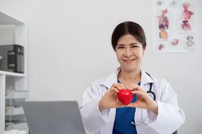 عکس دکتر جوان خوشحال و زن سالخورده با قلب قرمز در دست، لبخند به دوربین