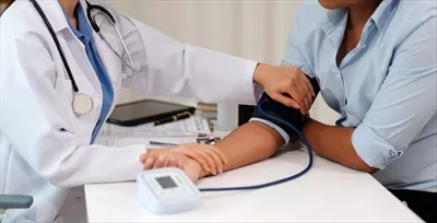 عکس دستگاه فشارسنج: بررسی فشار خون بیمار توسط پزشک زن در معاینه پزشکی