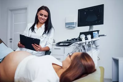 عکس پزشک زن درباره نتایج سونوگرافی برای یک زن باردار در بیمارستان توضیح می دهد
