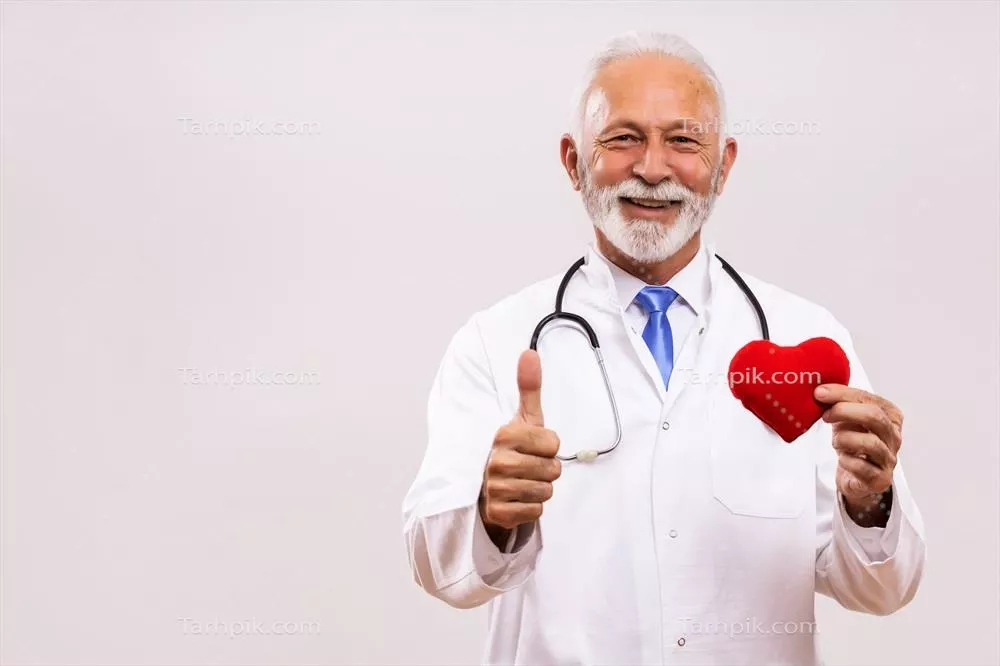 عکس پرتره ای از پزشک سالخورده با گوشی پزشکی در حال نشان دادن شکل قلب و علامت تایید