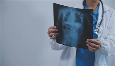 عکس دکتر مسلمان آسیایی با حجاب و لباس پزشکی در مطب پزشکی