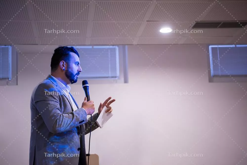 عکس مدیر موفق در حال ارائه در یک اتاق کنفرانس با مخاطبان حرفه ای