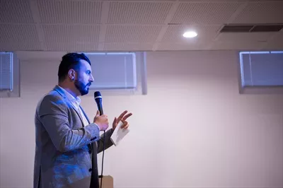 عکس مدیر موفق در حال ارائه در یک اتاق کنفرانس با مخاطبان حرفه ای