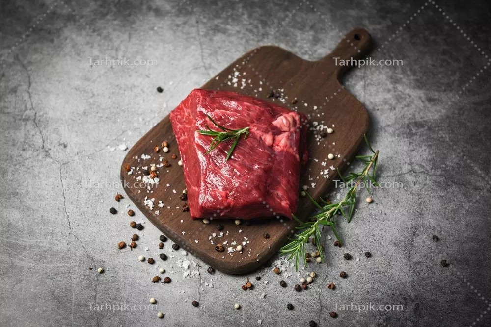 عکس استیک گوشت قرمز تازه با ادویه و سبزیجات بر روی تخته چوبی