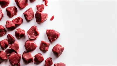 عکس گوشت خام گوساله بر روی پس زمینه سفید با نمای بالا و فضای خالی