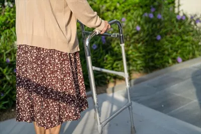 عکس زنی مسن و سالمند در پارک با واکر، نماد قدرت و سلامتی