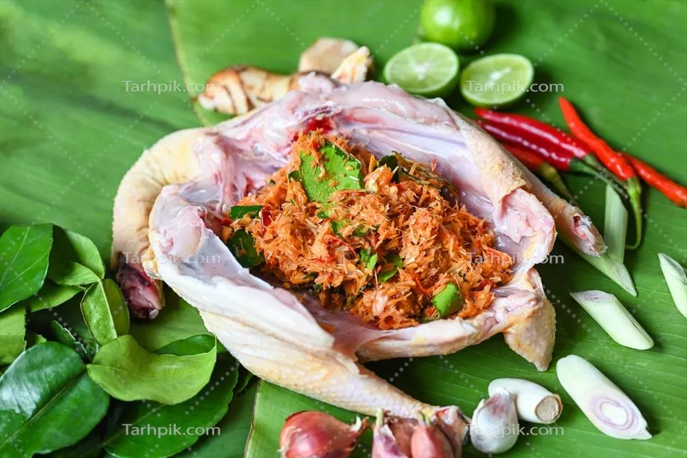 عکس آشپزی غذاهای تایلندی با مرغ تازه و سبزیجات معطر بر روی برگ موز