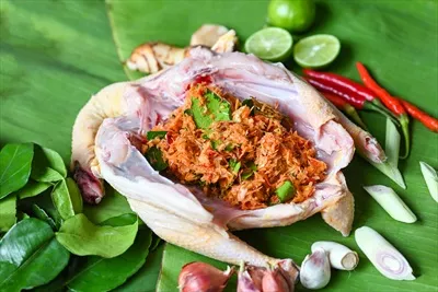 عکس آشپزی غذاهای تایلندی با مرغ تازه و سبزیجات معطر بر روی برگ موز