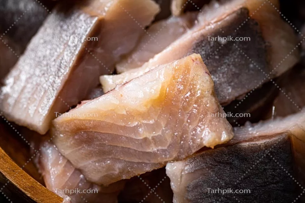 عکس قطعات خوشمزه هیرینگ نمک زده بر روی تخته سنگی - یک تجربه لذیذ