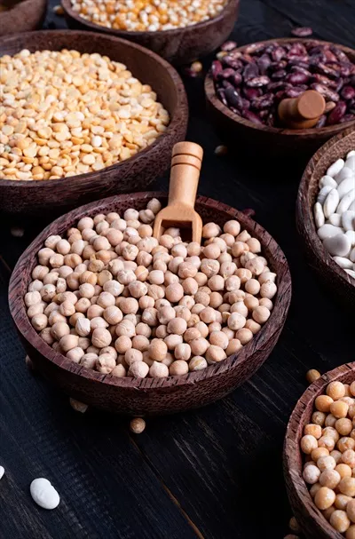 عکس مجموعه ای از حبوبات خشک در کاسه های چوبی بر روی پس زمینه چوبی