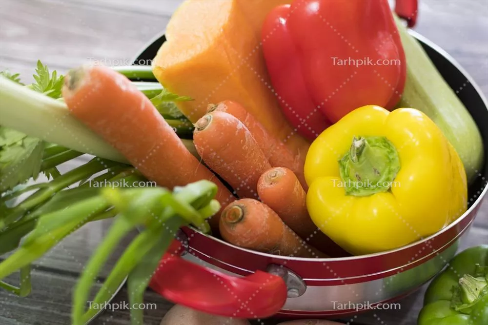 عکس سبزیجات تازه و خوشمزه برای تهیه سوپ در قابلمه قرمز