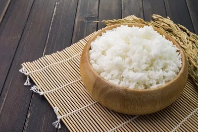 عکس تصویری نزدیک از برنج سفید یا برنج یاسمین در کاسه چوبی
