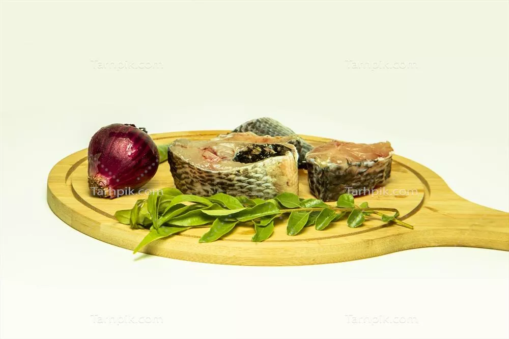 عکس ماهی تازه و خام با ادویه جات و گیاهان معطر روی تخته چوبی