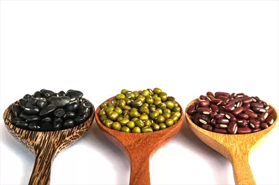عکس ترکیب خوشمزه حبوبات در قاشق چوبی بر روی زمینه سفید